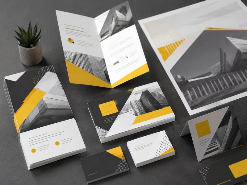 A mockup of printed marketing materials, including a tri-fold brochure, business cards, a table tent card and a poster